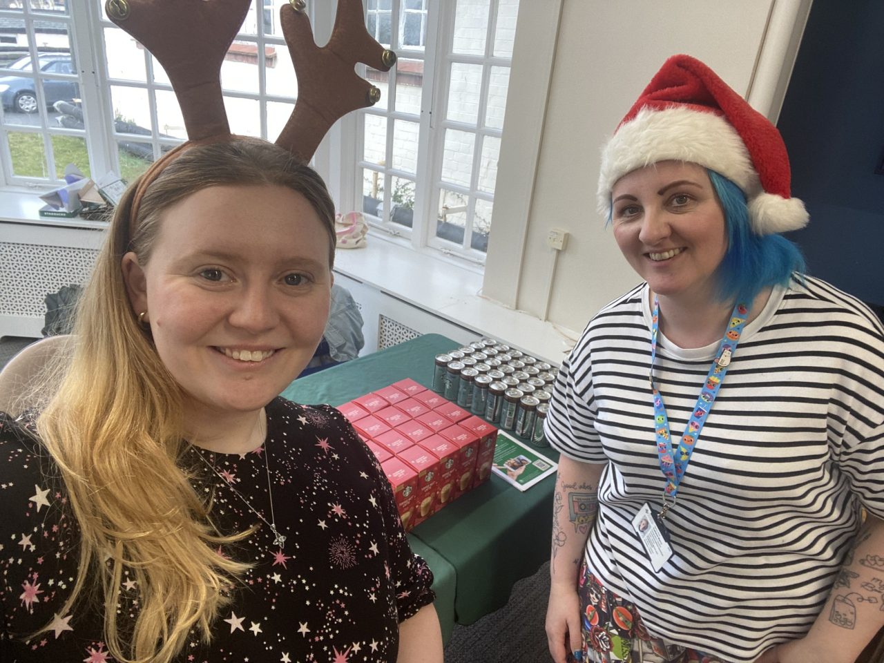 Delwedd o Dîm Elusen Iechyd Powys gyda chynnyrch Starbucks am ddim wedi'i sefydlu yn y cantin yn Bronllys